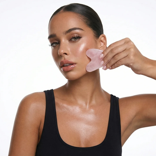Femme utilisant un gua sha sur le visage pour favoriser le drainage, améliorer les contours du visage et compléter la routine SweetLifty.